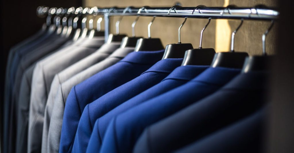 Close-up of neatly arranged suits in a wardrobe, showcasing fashion and organization.